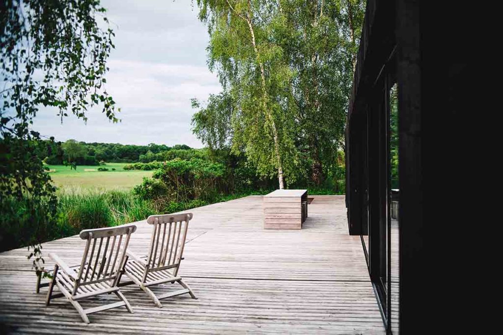 Wood deck on back of home overlooking lush green land